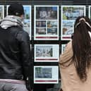 People look at residential properties displayed for sale in the window of an estate agents' in London (Photo: ISABEL INFANTES/AFP via Getty Images)