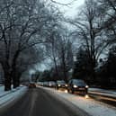 Cars drive on snowy roads in Liverpool.
