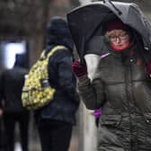Woman walks in stormy conditions.