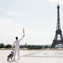 Torch bearer Matthias Dandois, French bicycle rider, poses for a photo with the Olympic Torch with the Eiffel Tower in view (Photo: Maja Hitij/Getty Images)