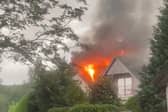 Flames pour from house roof after it’s struck by lightning.