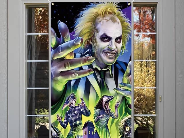Beetlejuice themed Halloween decorations like this door cover are all the rage this year