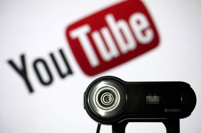 File photo of a camera positioned in front of YouTube's logo. Photo: LIONEL BONAVENTURE/AFP via Getty Images