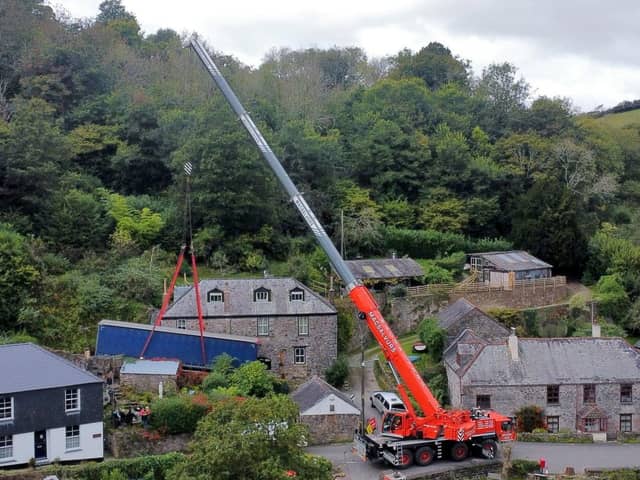 A truck is removed by a crane after getting stuck on a narrow lane in Forder near Saltash, Cornwall.
