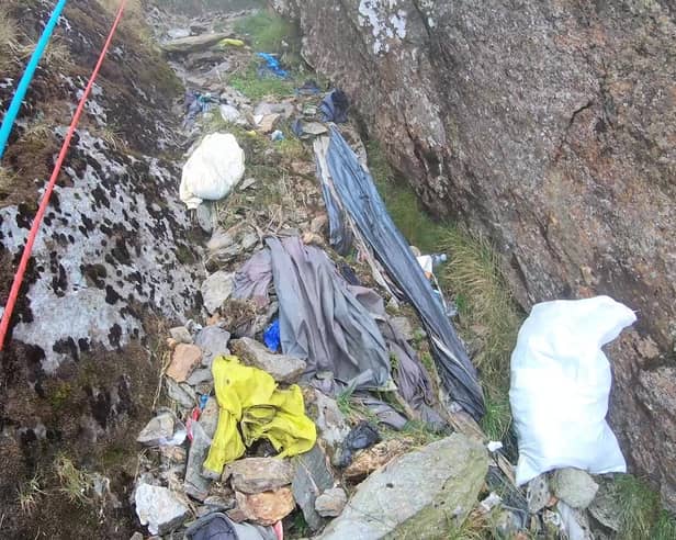 Video grab from heartbreaking footage showing 'waterfalls' of 3,000 bits of rubbish including drinks cans and Santa hats left by people on Mount Snowdon.