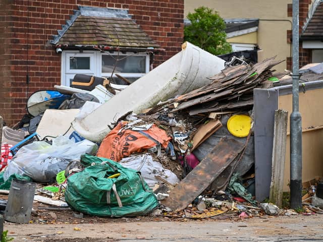 Horrified residents are demanding action after their neighbours turned their home into a makeshift TIP with tonnes of rubbish dumped on the driveway.  