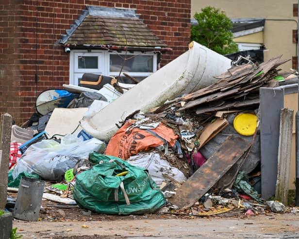 Horrified residents are demanding action after their neighbours turned their home into a makeshift TIP with tonnes of rubbish dumped on the driveway.  