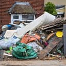Horrified residents are demanding action after their neighbours turned their home into a makeshift TIP with tonnes of rubbish dumped on the driveway.  