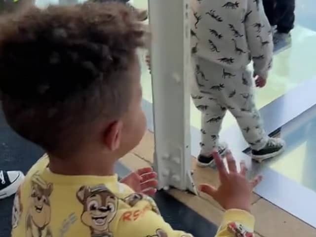 Mason Gee, 3, worried about his father Stephen Gee, 30, walking on a glass walkway