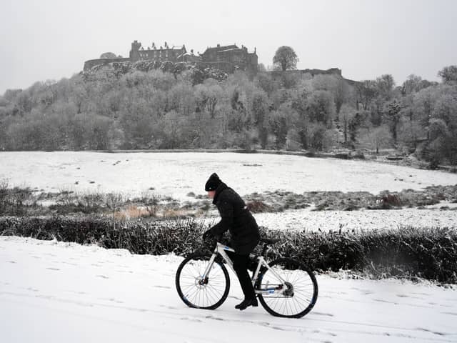 A person rides a bicycle in the snow at Stirling Castle.