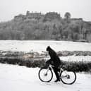 A person rides a bicycle in the snow at Stirling Castle.