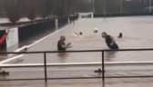 Lydney Town AFC players go swimming on their pitch.
