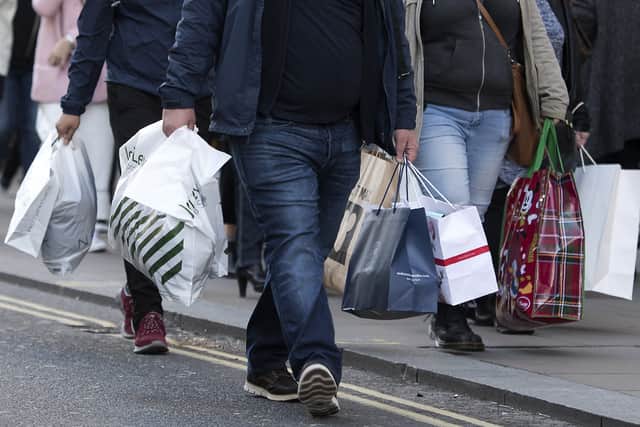 Shoppers walk down street.