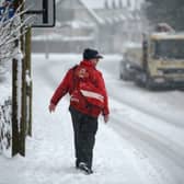 A postman makes his way through the snow.