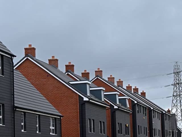 An electricity pylon is pictured beyond newly built residential properties at a construction site for new houses and homes near Aylesbury in July 2023 (Photo: JUSTIN TALLIS/AFP via Getty Images)