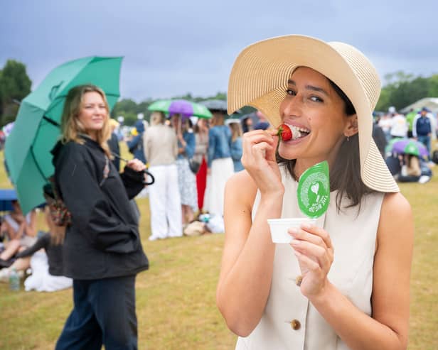 Tennis fan spotted dipping traditional strawberries into Dominos garlic and herd dip in the queue at Wimbledon