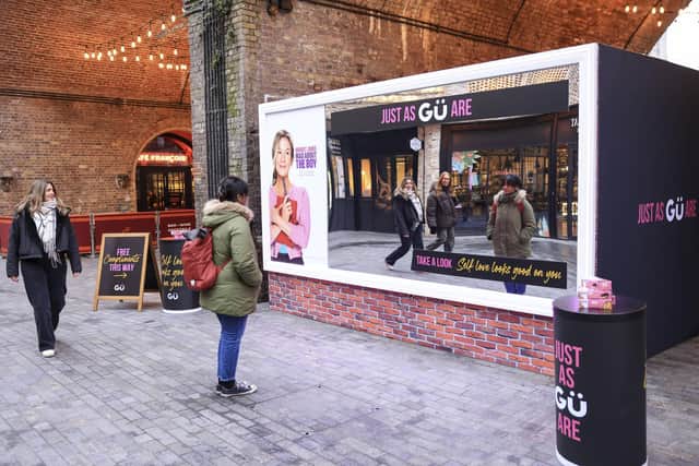 A member of the public interacts with an activation in Borough Yards by Gü to celebrate the launch of Bridget Jones: Mad About the Boy. This Valentine’s week, Gü has unveiled the UK’s first complimenting billboard. The interactive activation serves uplifting compliments inspired by beloved characters from the Bridget Jones franchise. Visitors can also enjoy full sized products from Gü’s signature range. A recent study, conducted by Gü, found that two thirds agreed that receiving a genuine compliment can turn their week around (68%) – not just their day.