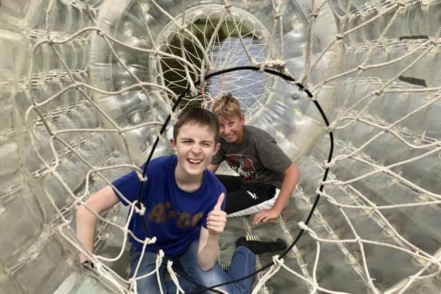 Two of NESS’s Young People's Sensory Service members enjoy playing in a zorbing ‘bubble tunnel’.