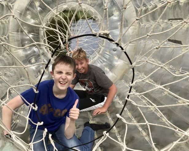 Two of NESS’s Young People's Sensory Service members enjoy playing in a zorbing ‘bubble tunnel’.