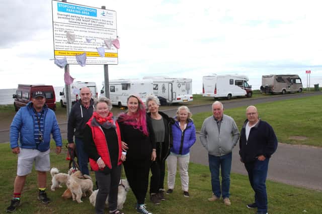 Suu Wighton and Karen Elliot are pictured with some of the disgruntled Motorhome owners in front of the new sign. (Wallace Ferrier)