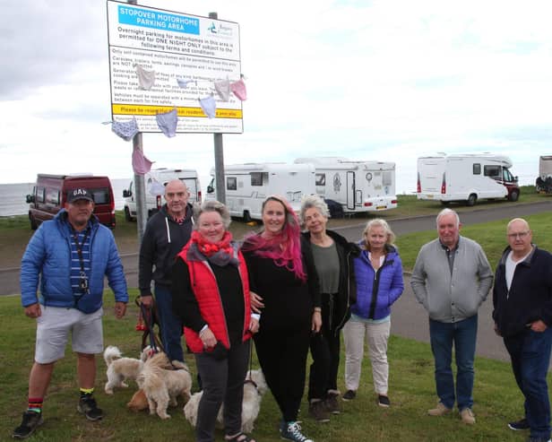 Suu Wighton and Karen Elliot are pictured with some of the disgruntled Motorhome owners in front of the new sign. (Wallace Ferrier)