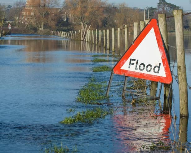 Flooded countryside road with warning sign in the UK.