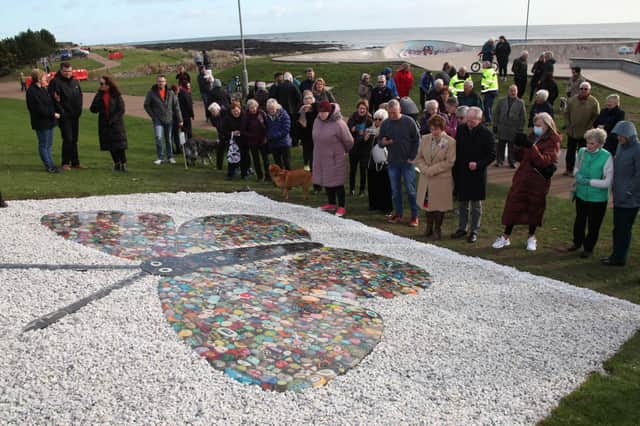 Members of the public admire the butterfly after its unveiling at the town’s seafront. (Wallace Ferrier)