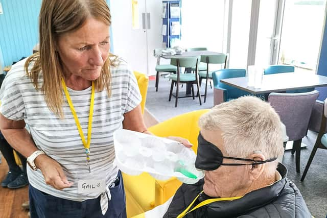 Gail gives Pete Fairy Liquid to identify by smell in the second session at Lochside Connections.