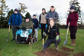 Senior Hub pupils are pictured with Pippa Paterson (front) from Scottish Woodlands planting one of the fruit trees in the new orchard. (Andy Thompson)