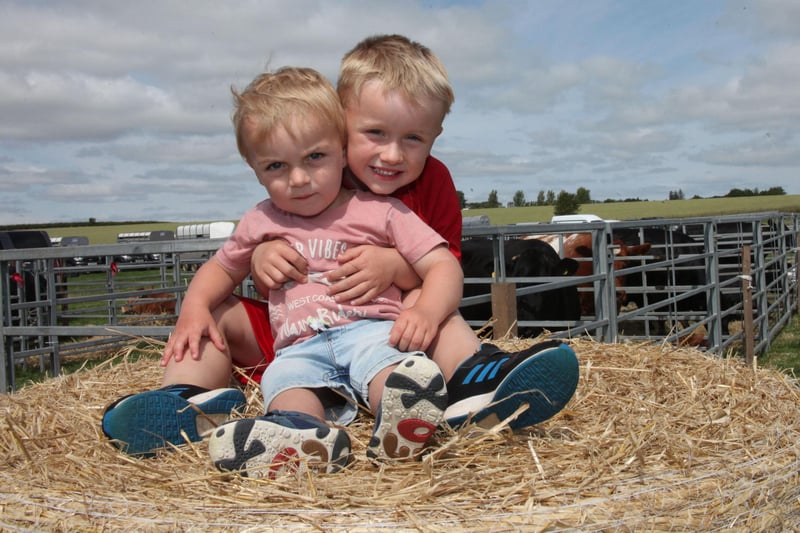 Cousins Reece Brownlie and Finlay Wilson enjoy the sun while playing on a straw bale.