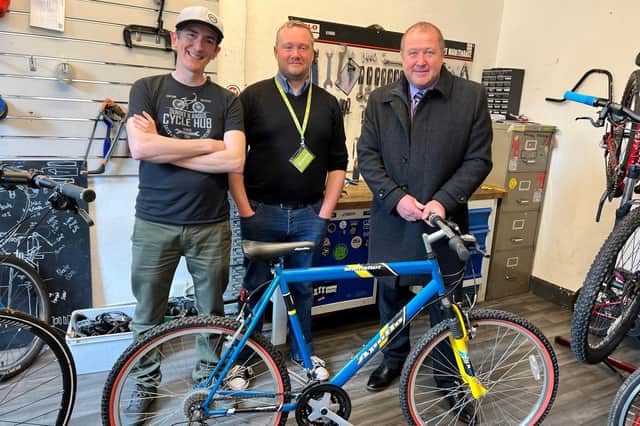 Graeme Dey is pictured with Scott Francis (left), David Evans (middle) and the bike he donated to the recycling scheme.