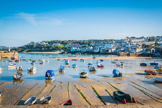 Fishing boats during low tide in the evening at sunset at the harbor of St Ives (Vivvi Smak - stock.adobe.com)