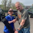 Stewart Falconer (right) handing over a prize to young angler Eryk Janik