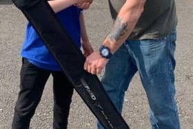 Stewart Falconer (right) handing over a prize to young angler Eryk Janik