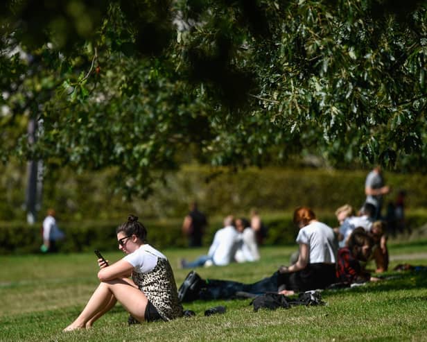 People enjoying a park on a warm day.