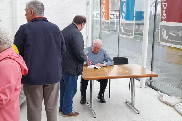 Robert Murray signs copies of his hew book for fans at the release event at Dundee Central Library.