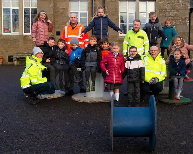 Pauline Allison and contractors are pictured with Murroes pupils.