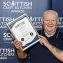 ​Butcher Jon Milne with the award for the business’s black pudding. (Pic: Graeme Hart)