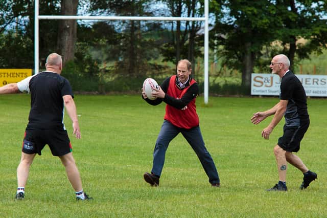 HRH The Earl of Forfar joins in a game of Walking Rugby with regular players and coaches in the trust’s project. Pictured defending are (left) Bob Baldie, President of Strathmore RFC and (right) Willie Gray.