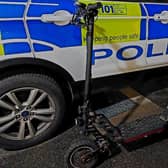 An e-scooter alongside a Police Scotland vehicle