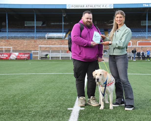 Jon Attenborough and his Labrador Sam with the SPFL's Molly Hyde at Station Park, Forfar. Picture: SPFL/Christopher Coutts/SWNS