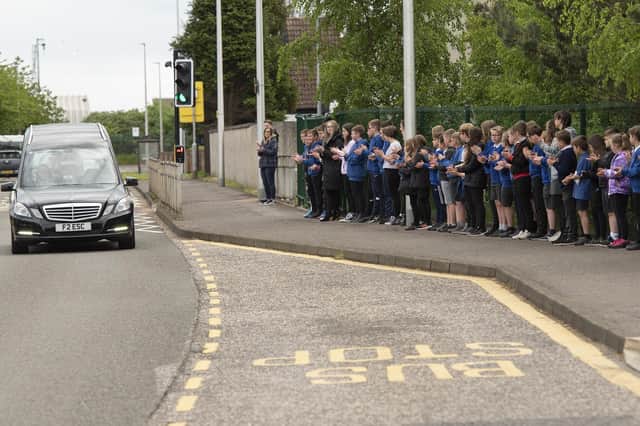 The funeral cortege of former head teacher Bill Tulloch is applauded by present day pupils and staff at Borrowfield Primary School. (Andy Thompson)