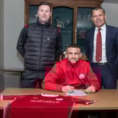 Nathan Cooney signs on at City watched on by Andy Kirk and chairman Kevin Mackie. Pic by Graeme Youngson